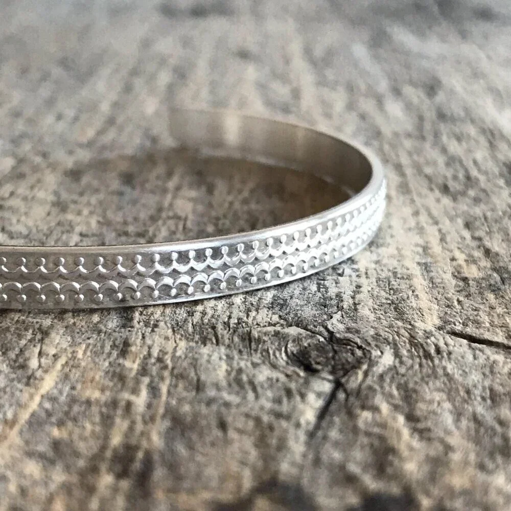 Brushed sterling silver scalloped open cuff bangle bracelet with satin finish.